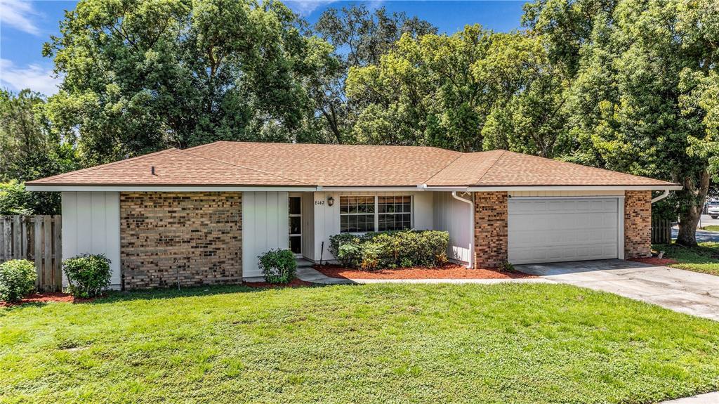A single-story house with a brick facade, a brown shingled roof, and an attached garage — 8142 GOLDEN SANDS DRIVE, ORLANDO, FL