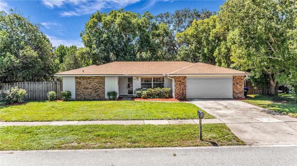 A single-story house with a brick facade, white siding, and an attached two-car garage — 8142 GOLDEN SANDS DRIVE, ORLANDO, FL