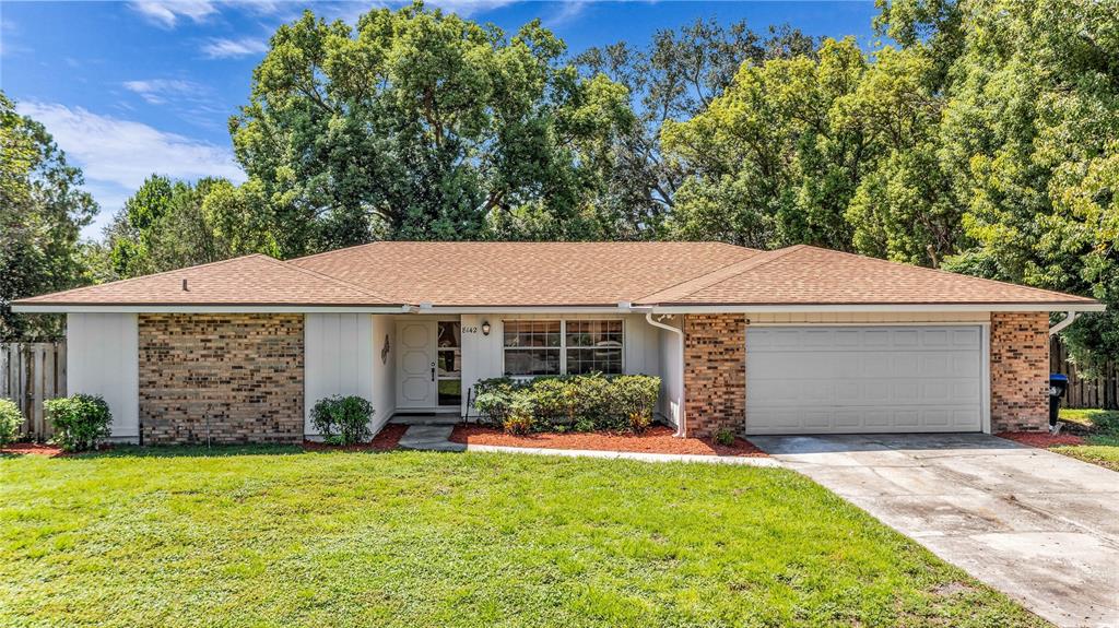 A single-story house with a brick facade, a two-car garage, and a concrete driveway — 8142 GOLDEN SANDS DRIVE, ORLANDO, FL