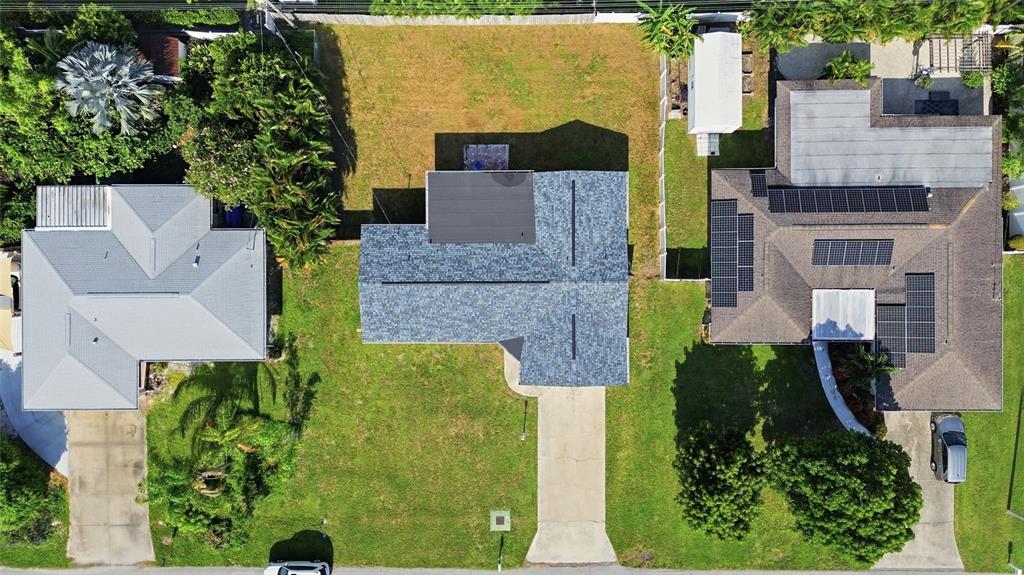 An aerial view shows three residential houses with driveways and yards in a suburban neighborhood — 1786 COCONUT DRIVE, VENICE, FL