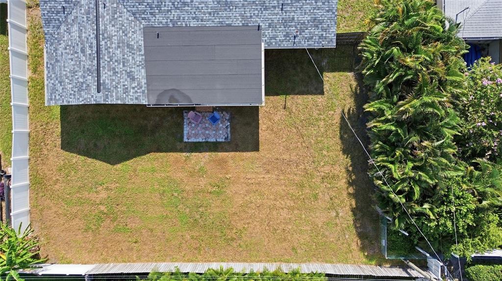 An aerial view shows a backyard with a patio, lawn, and surrounding privacy fences — 1786 COCONUT DRIVE, VENICE, FL