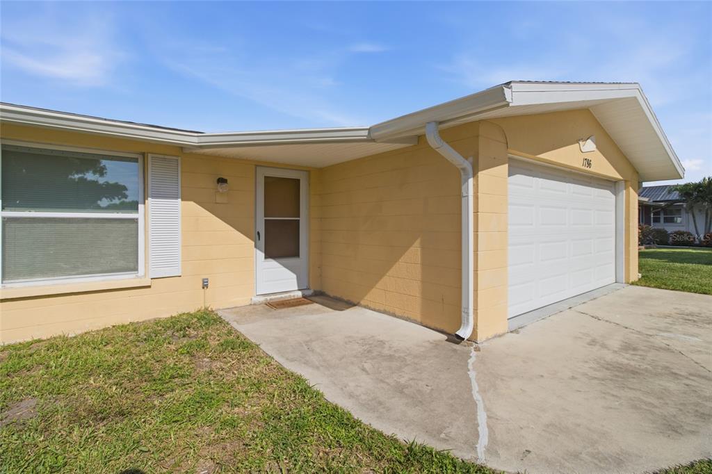 A yellow single-story house features a concrete driveway, a one-car garage, and a front entrance — 1786 COCONUT DRIVE, VENICE, FL