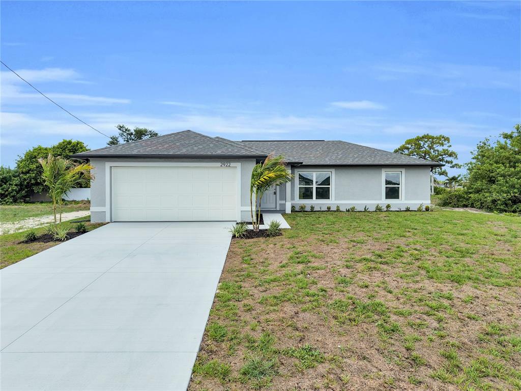 A bright, open-concept kitchen and living area features white cabinetry and polished marble-look flooring — 1808 NE 44TH STREET, CAPE CORAL, FL
