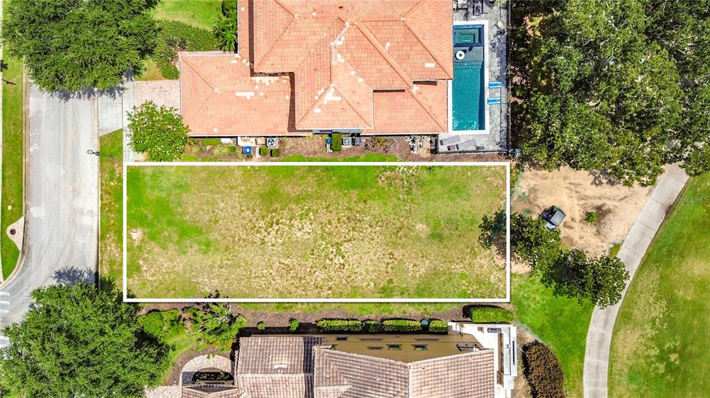 An aerial view shows a rectangular vacant residential lot situated between two houses — 1221 RADIANT STREET, KISSIMMEE, FL