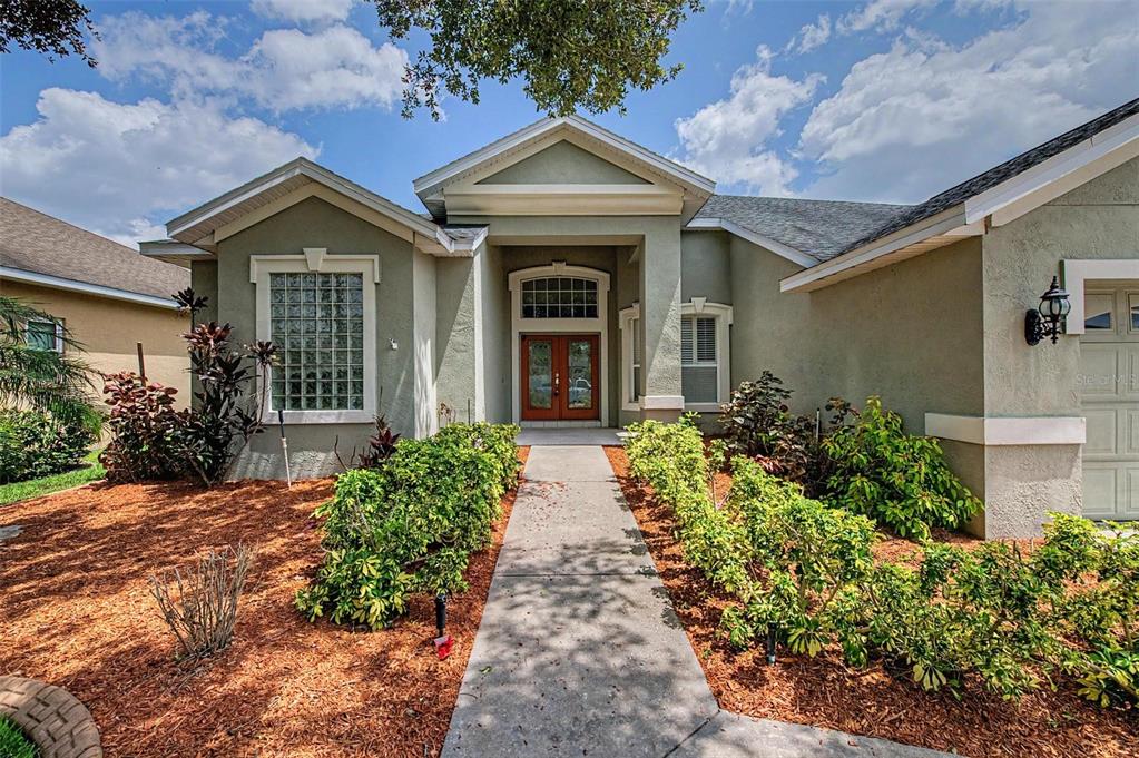 A single-story house with a stucco exterior, a glass block window, and a concrete walkway — 4332 SWIFT CIRCLE, VALRICO, FL