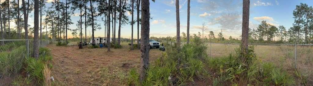 A panoramic view shows a fenced, wooded lot with a parked truck and a small trailer — 6718 OWENS ROAD, ST CLOUD, FL