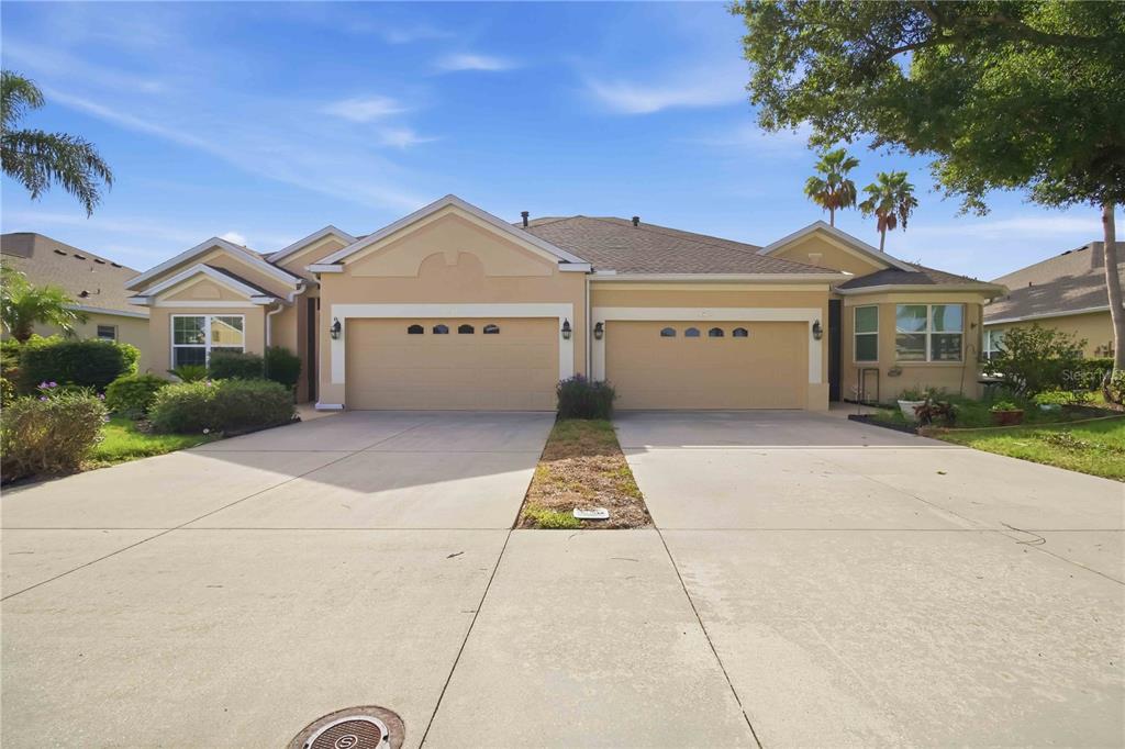 A single-story house with a tan stucco exterior and two side-by-side garage doors — 3312 92ND AVENUE E, PARRISH, FL