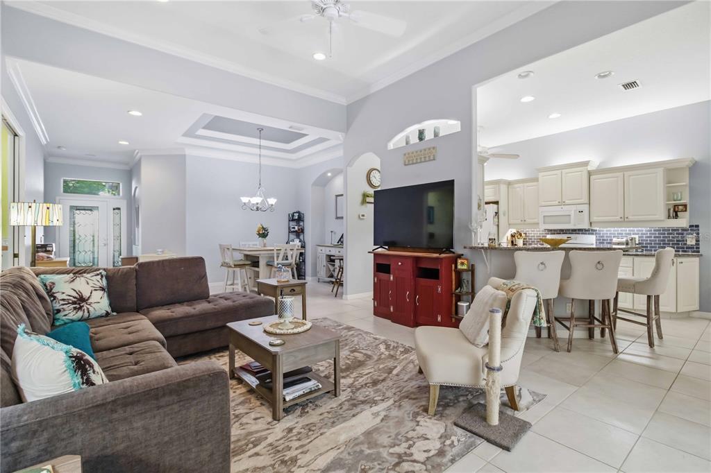 A living room with a brown sectional sofa, television, and an open kitchen with bar seating — 3312 92ND AVENUE E, PARRISH, FL