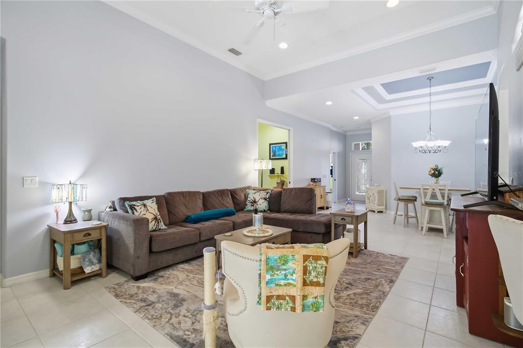 A living room with a brown sectional sofa, a patterned rug, and an adjacent dining area — 3312 92ND AVENUE E, PARRISH, FL