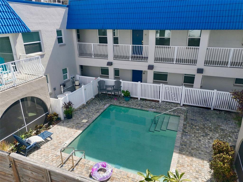 An aerial view shows a multi-story apartment complex near a beach and ocean — 17035 GULF BOULEVARD UNIT 216, NORTH REDINGTON BEACH, FL