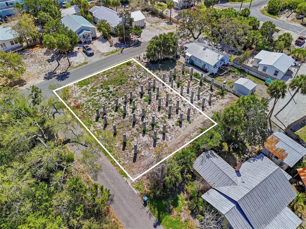 An aerial view shows a vacant residential lot featuring numerous concrete pilings for a future structure — TBD 3RD STREET, CEDAR KEY, FL