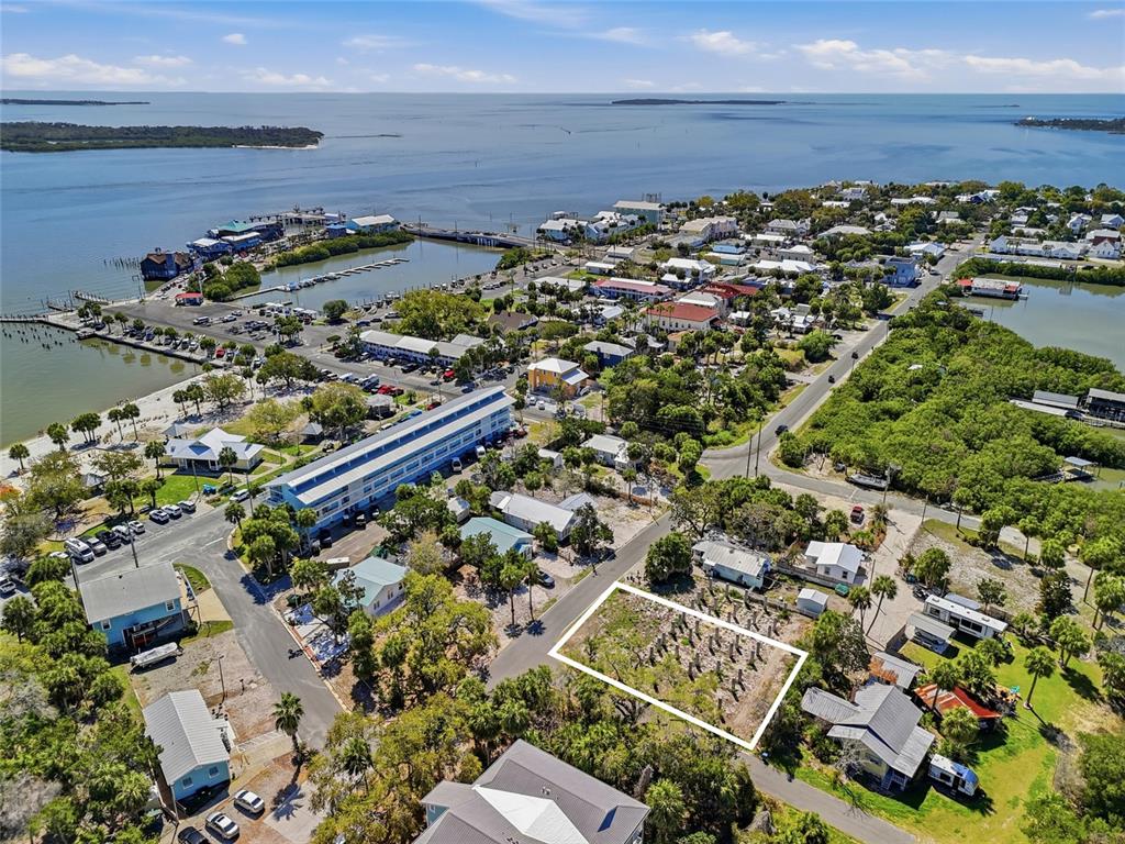 An aerial view shows a vacant, rectangular lot outlined in white within a coastal town — TBD 3RD STREET, CEDAR KEY, FL