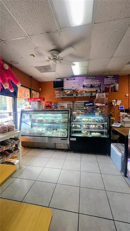 A bakery interior features glass display cases, a menu board, and tiled flooring — 1450 SKIPPER ROAD, TAMPA, FL