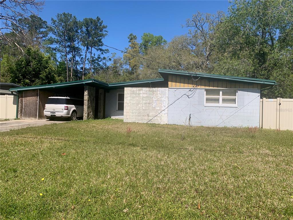A single-story house with a carport, concrete block walls, and a sloped roof — 8029 CHATEAU DRIVE S, JACKSONVILLE, FL