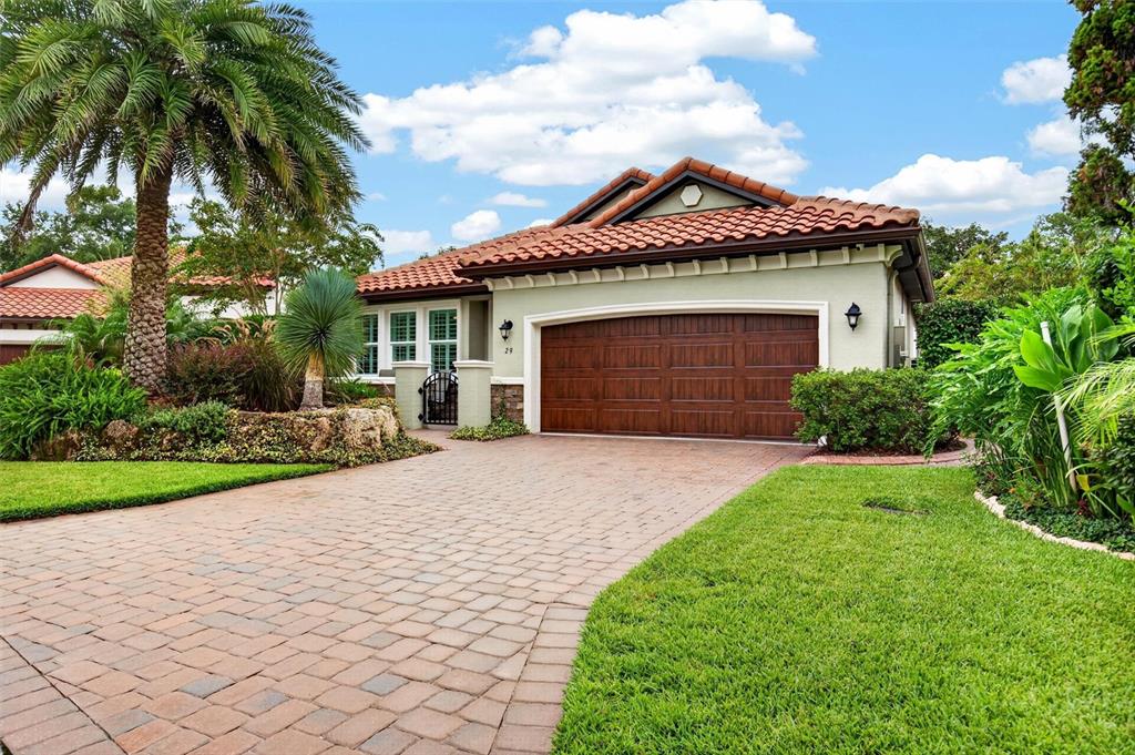 A single-story house with a tiled roof, a brown garage door, and a paved driveway — 29 APIAN WAY, ORMOND BEACH, FL