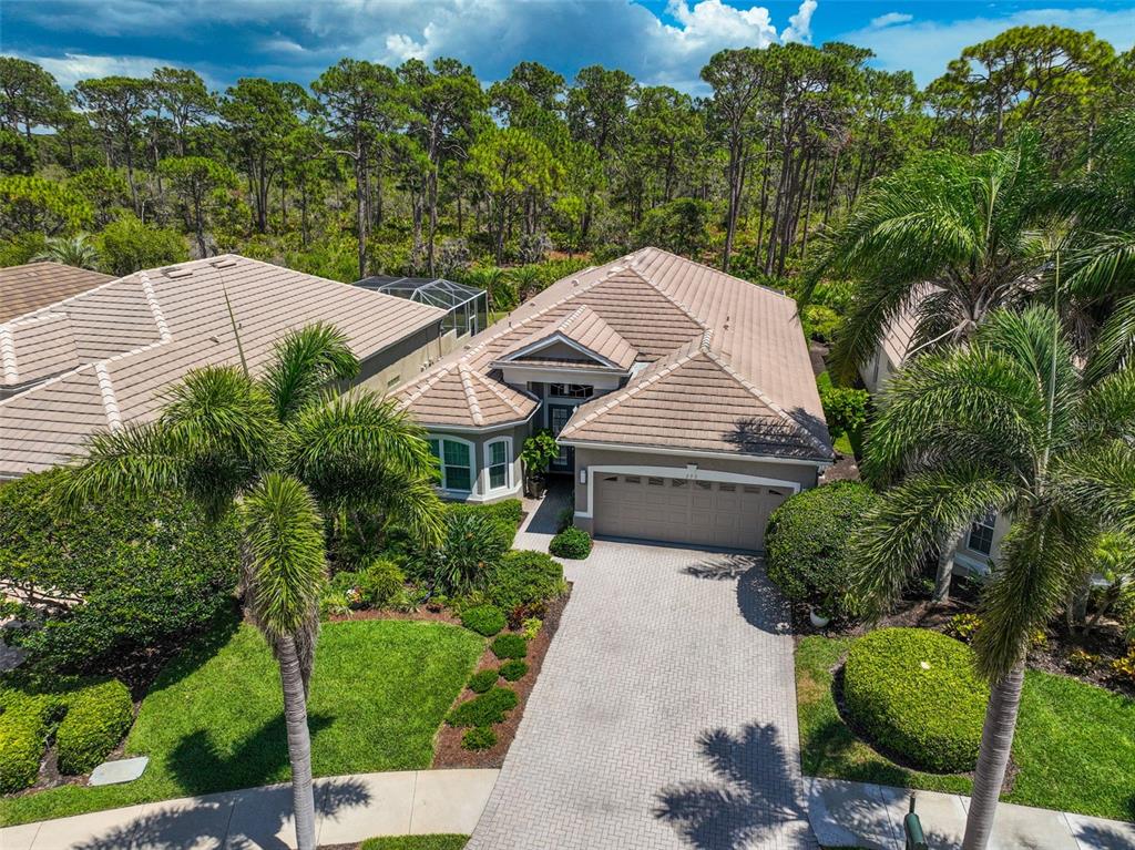 An aerial view of a single-story house with a tiled roof, garage, and landscaped yard — 293 TURQUOISE LANE, OSPREY, FL