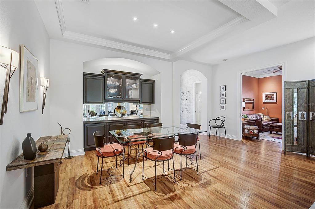 A dining room features a glass table, dark cabinetry, and hardwood floors — 293 TURQUOISE LANE, OSPREY, FL