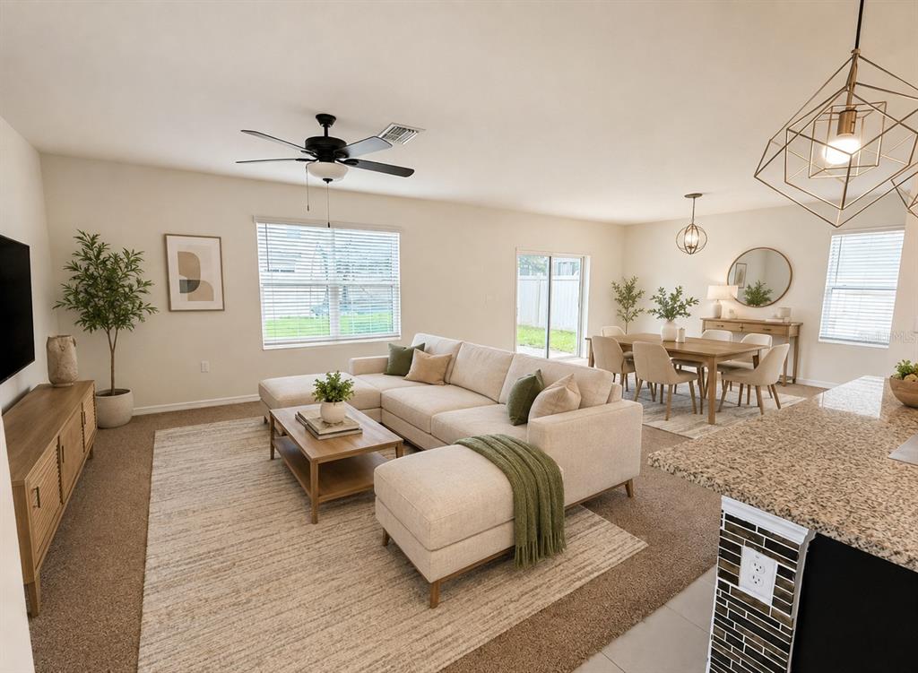 A two-story tan stucco house features a front-facing garage and a covered entryway — 32649 PEZ LANDING LANE, WESLEY CHAPEL, FL
