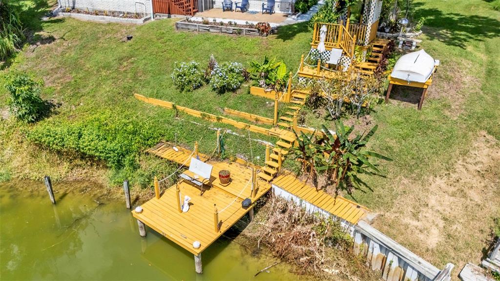 An aerial view of a wooden deck and staircase leading to a dock on water — 2055 S FLORAL AVENUE UNIT 165, BARTOW, FL