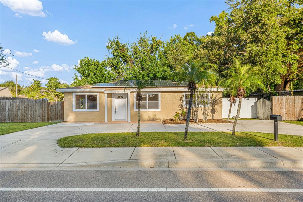 A single-story tan house with a flat roof and a wooden fence in the yard — 2913 MCINTOSH ROAD, SARASOTA, FL