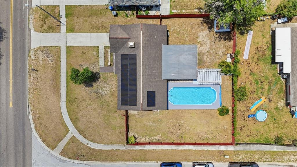 An aerial view shows a house with solar panels, a swimming pool, and a fenced yard — 5020 PINE STREET, SEFFNER, FL