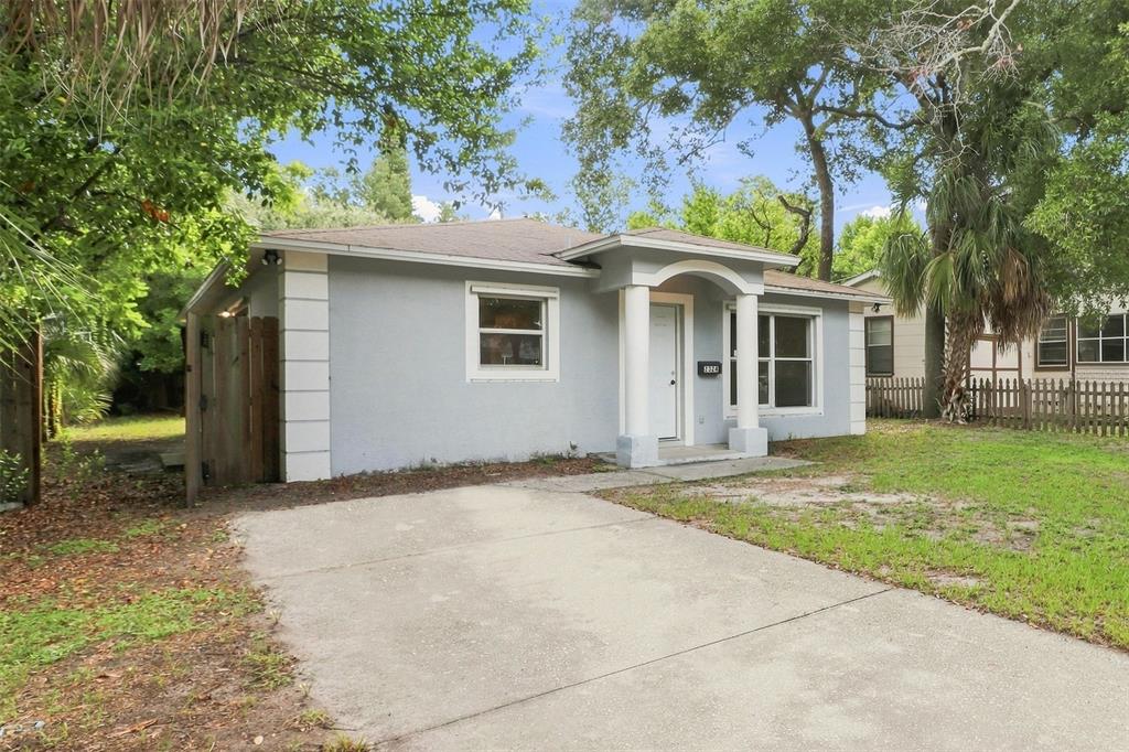 A single-story gray house with a concrete driveway, white columns, and a small front porch — 2324 OAKDALE STREET S, ST PETERSBURG, FL