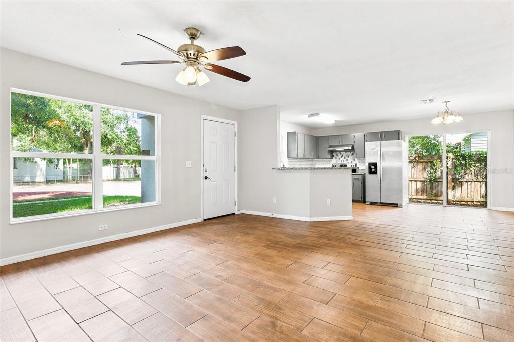 An open-concept living room and kitchen with wood-look tile flooring and a ceiling fan — 2324 OAKDALE STREET S, ST PETERSBURG, FL
