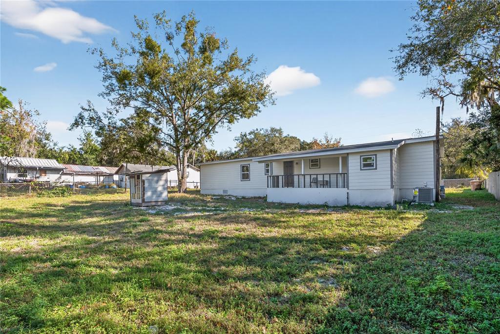 A single-story house with light siding and a small porch sits on a grassy lot — 40415 COUNTRY ROAD, EUSTIS, FL