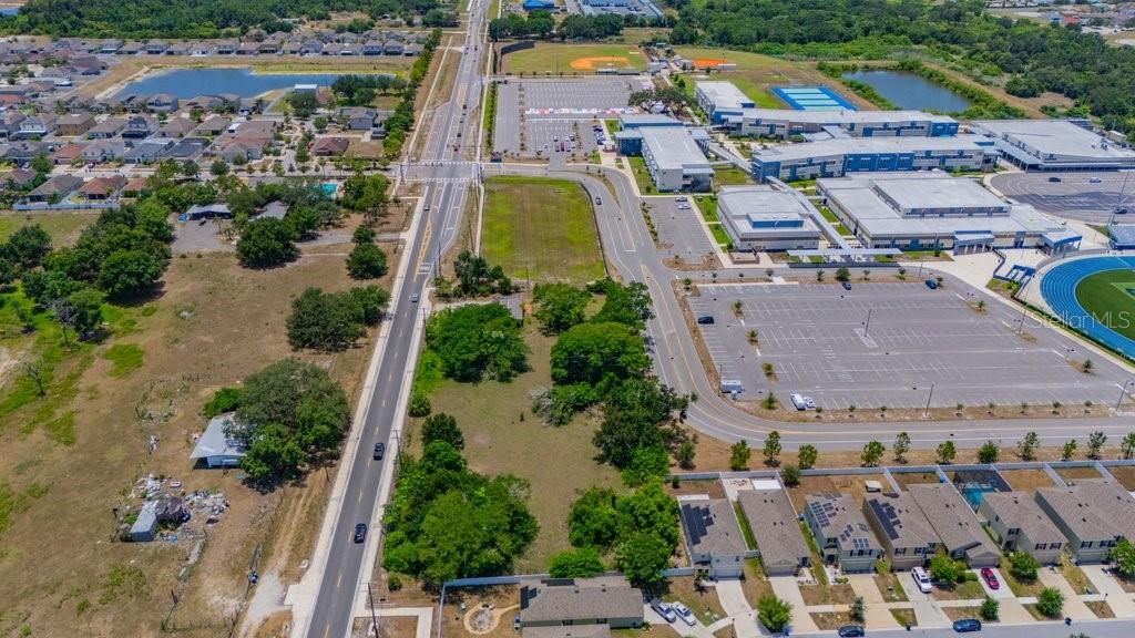 An aerial view shows a large school complex, parking lots, and surrounding residential neighborhoods — 10912 672 HIGHWAY, RIVERVIEW, FL