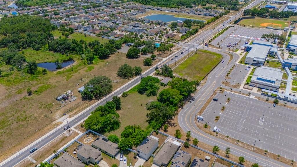 An aerial view shows a vacant lot situated between a residential neighborhood and a commercial complex — 10912 672 HIGHWAY, RIVERVIEW, FL