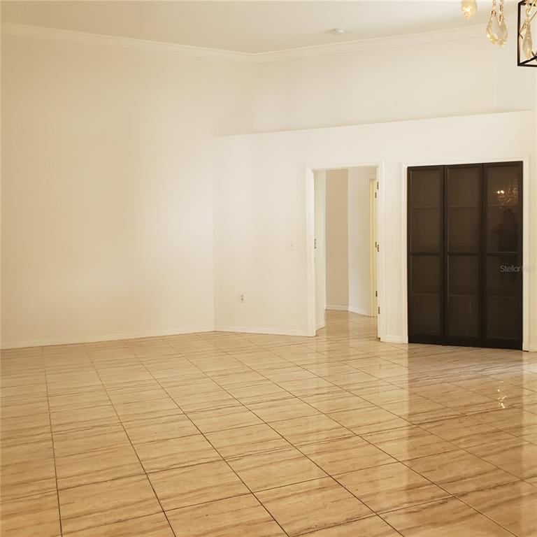 A spacious room features light-colored tile flooring, white walls, and a dark-framed glass closet — 3011 PARTRIDGE POINT TRAIL, VALRICO, FL