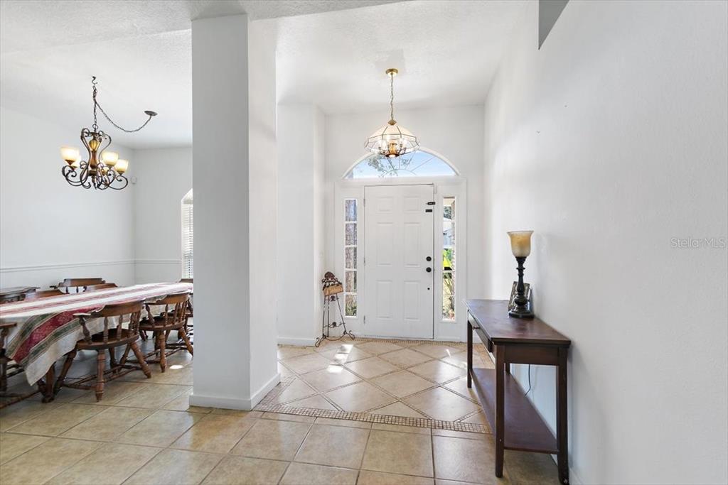 A tiled entryway features a white front door with sidelights and an adjacent dining area — 38 RED MILL DRIVE, PALM COAST, FL
