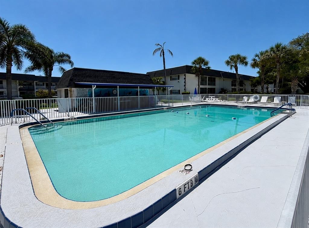 An outdoor apartment walkway features a white stucco wall, a screen door, and unit 305 — 4705 5TH STREET W UNIT 305, BRADENTON, FL