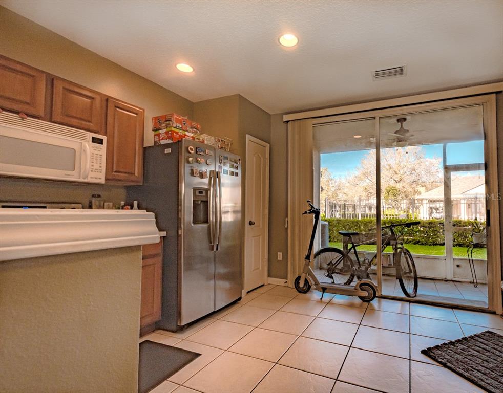 A kitchen with wood cabinets, stainless steel appliances, and a sliding door to a patio — 4535 KENNEWICK PLACE, RIVERVIEW, FL