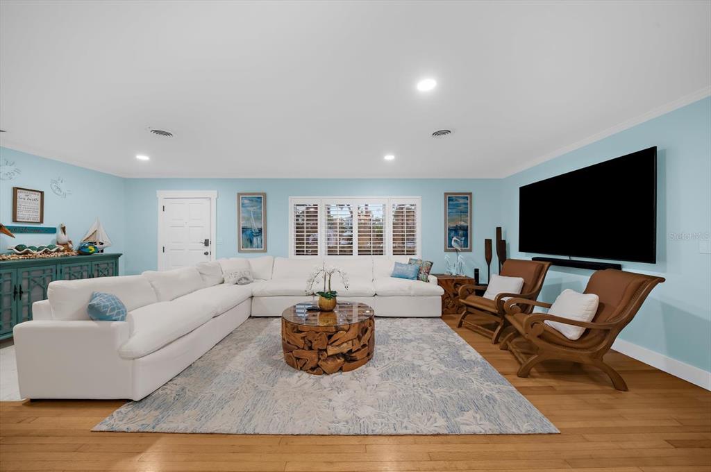 A living room features a white sectional sofa, wooden coffee table, and two brown chairs — 751 MANDALAY AVENUE, CLEARWATER BEACH, FL
