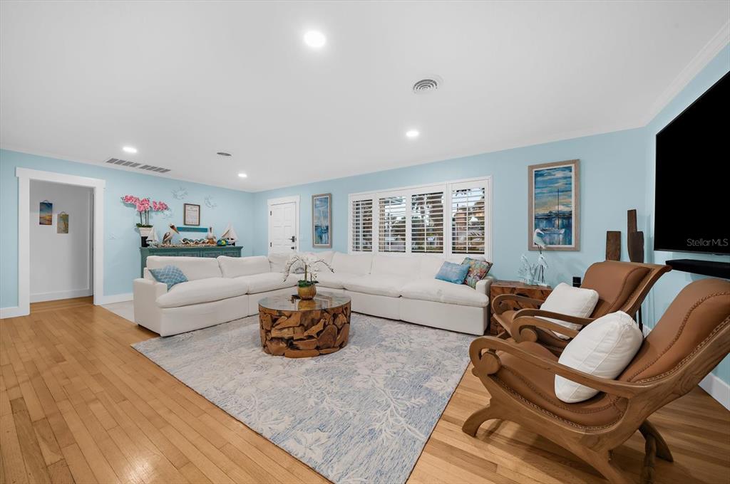 A living room features a white sectional sofa, a wooden coffee table, and two armchairs — 751 MANDALAY AVENUE, CLEARWATER BEACH, FL