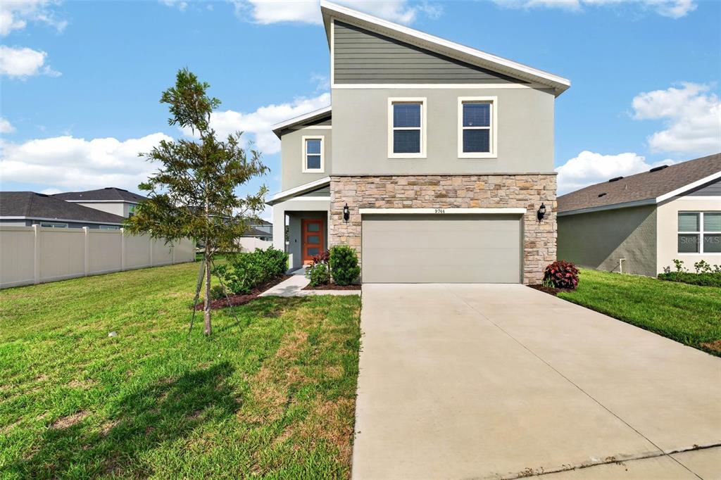 A two-story house with a stone facade, a two-car garage, and a concrete driveway — 9744 CRESCENT RAY DRIVE, WESLEY CHAPEL, FL