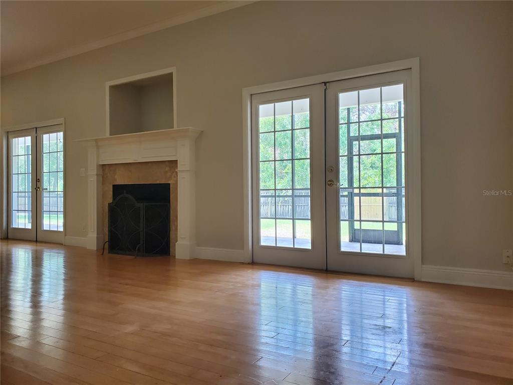 A foyer with wood-look flooring, a carpeted staircase with a wooden railing, and a chandelier — 2121 FAIRFIELD AVENUE, BRANDON, FL