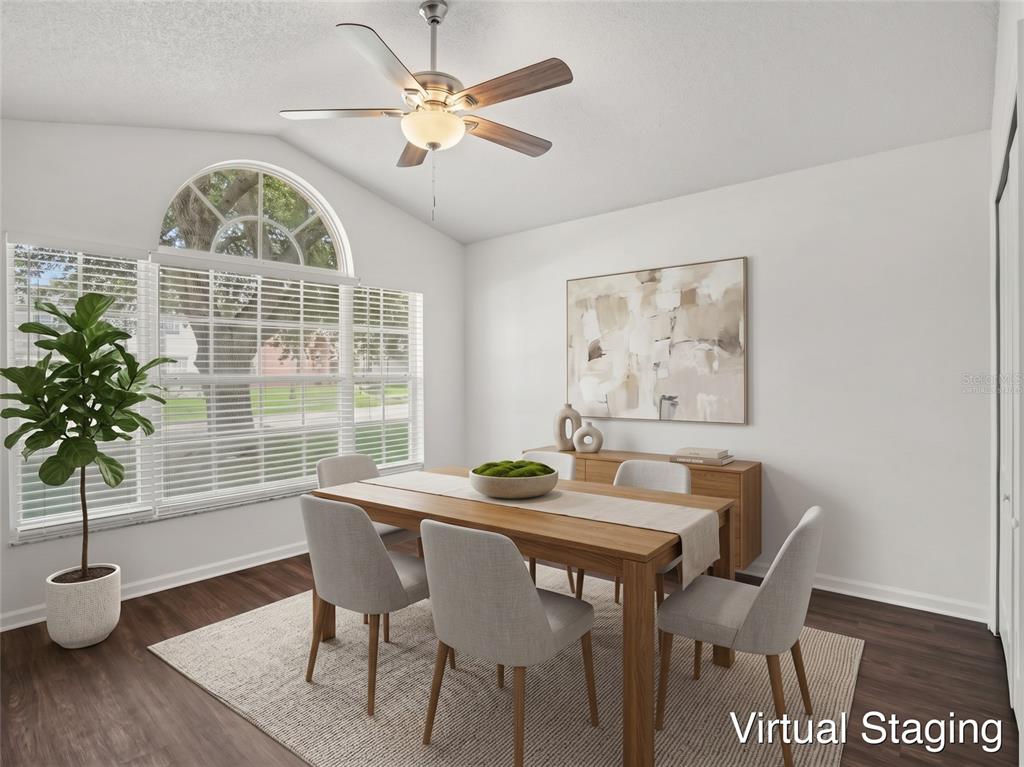 A spacious room with white walls, dark wood-look flooring, a ceiling fan, and arched window — 15854 BAY VISTA DRIVE, CLERMONT, FL