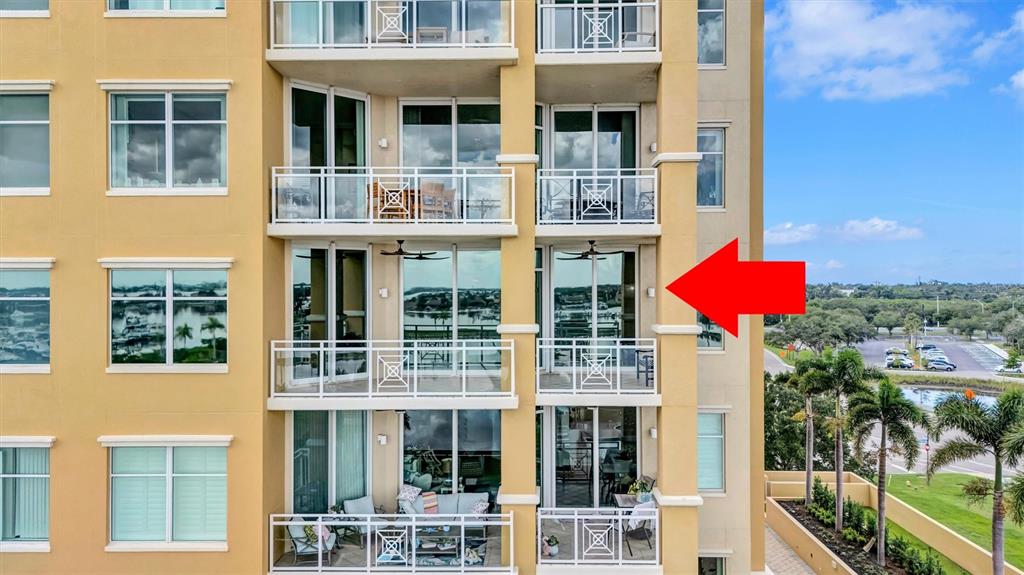 An exterior view of a multi-story apartment building featuring balconies with glass railings — 140 RIVIERA DUNES WAY UNIT 401, PALMETTO, FL