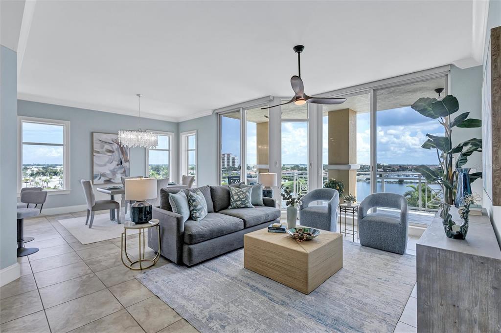 A living and dining area with a grey sofa, light wood coffee table, and floor-to-ceiling windows — 140 RIVIERA DUNES WAY UNIT 401, PALMETTO, FL