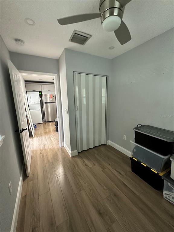 A room with light gray walls, wood-look flooring, a ceiling fan, and a folding closet door — 4521 EDGEWATER DRIVE UNIT 2, ORLANDO, FL