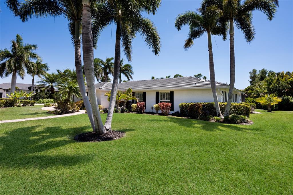 A single-story house with a paved walkway, palm trees, and a green lawn — 430 BIRD KEY DRIVE, SARASOTA, FL