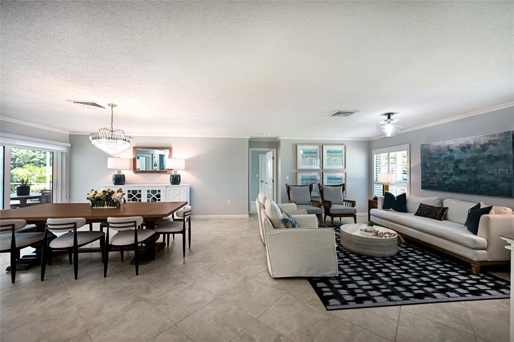 An open-concept living and dining area features tile flooring, neutral walls, and modern furniture — 430 BIRD KEY DRIVE, SARASOTA, FL