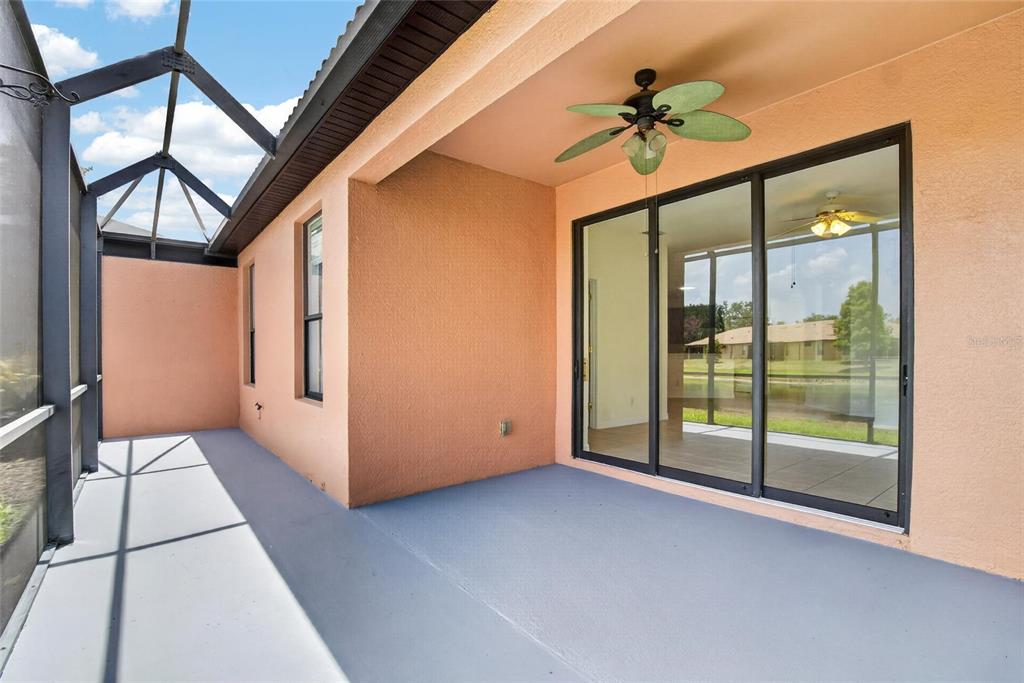 A covered patio with a ceiling fan, gray flooring, and sliding glass doors — 132 SHELL FALLS DRIVE, APOLLO BEACH, FL