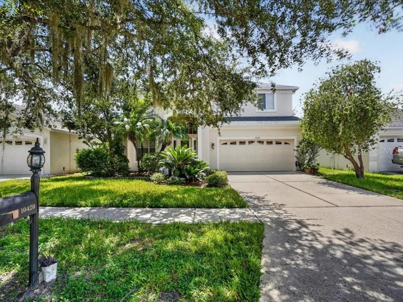 A two-story suburban house with a two-car garage, a concrete driveway, and a front lawn — 10420 LUCAYA DRIVE, TAMPA, FL