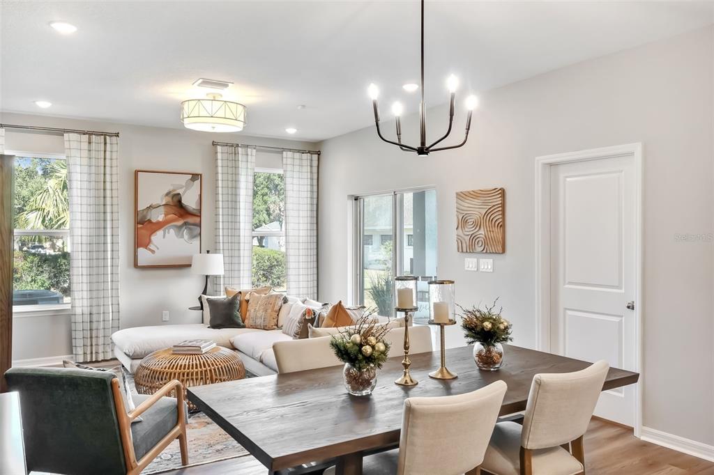A dining area with a wooden table and chairs opens into a living room space — 2291 RED PINE COURT, EUSTIS, FL