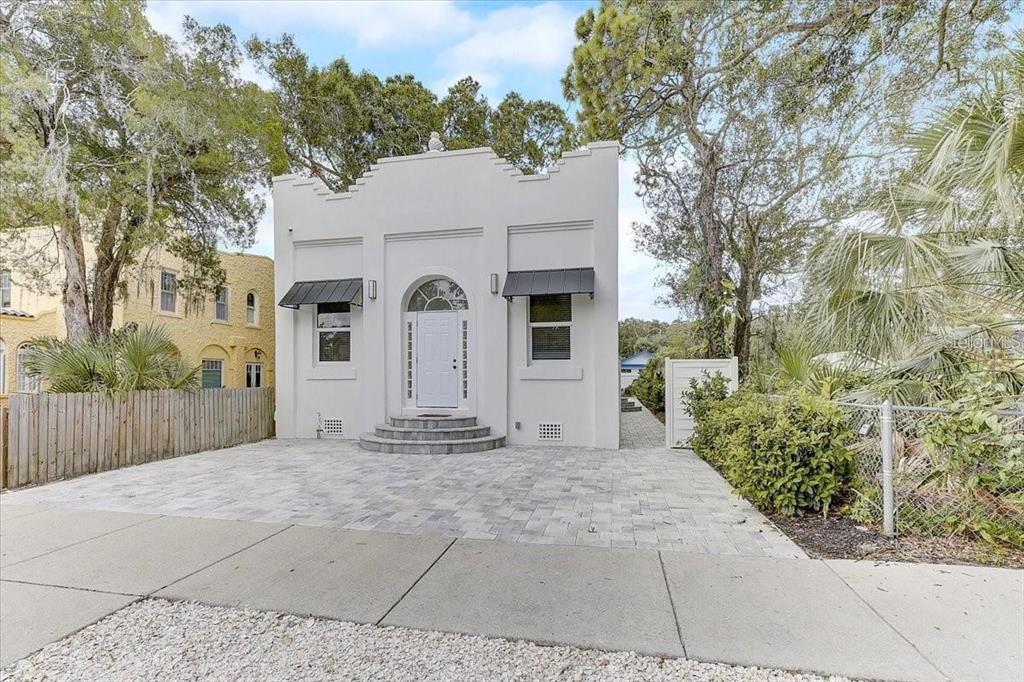 A white, single-story building with a stepped roofline and a paved front driveway — 1862 6TH STREET, SARASOTA, FL