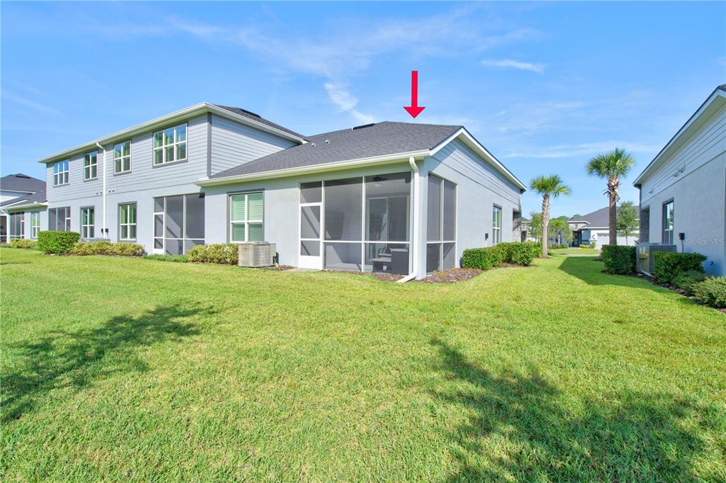 The exterior of a two-story house features a screened-in patio and a grassy backyard — 30 LONGRIDGE LANE, ORMOND BEACH, FL