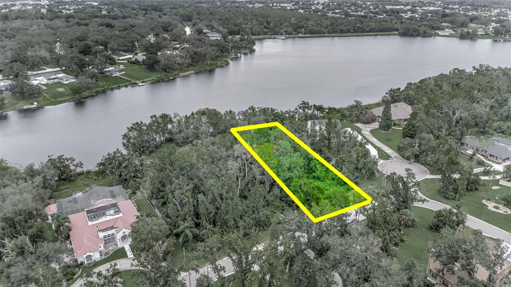 An aerial view shows a rectangular vacant lot outlined in yellow near a lake — 12612 LAKE HILLS DRIVE, RIVERVIEW, FL